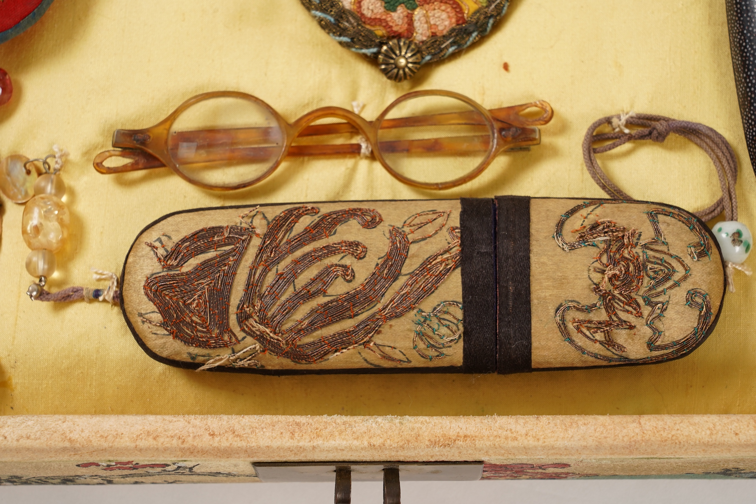 A collection of 19th/20th century Chinese embroidered silk spectacle cases and various spectacles, Box 33cm square